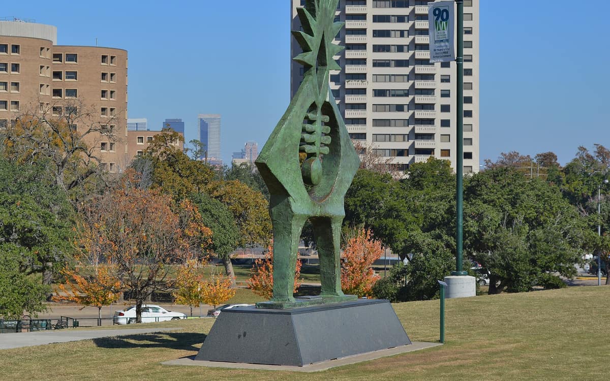 Sculpture in Hermann Park with Museum District buildings in the background